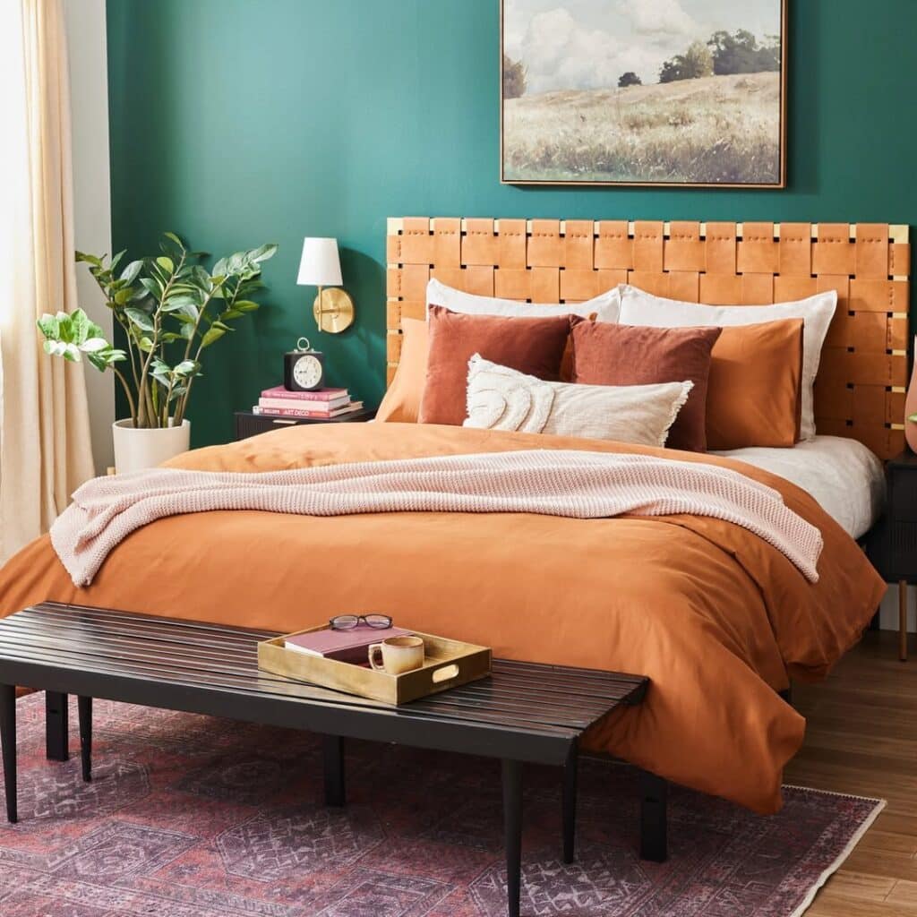 Teal orange off-white indigo and terracotta bedroom with a woven headboard and brass sconces