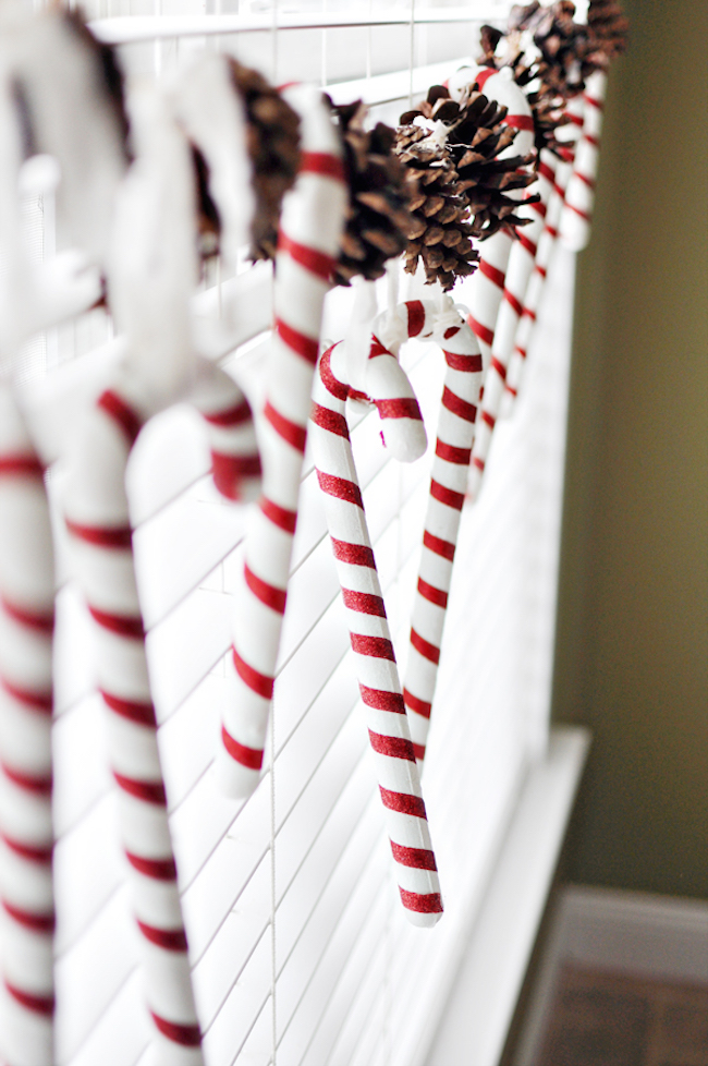 Candy canes and pinecones hung as Christmas window decorations.
