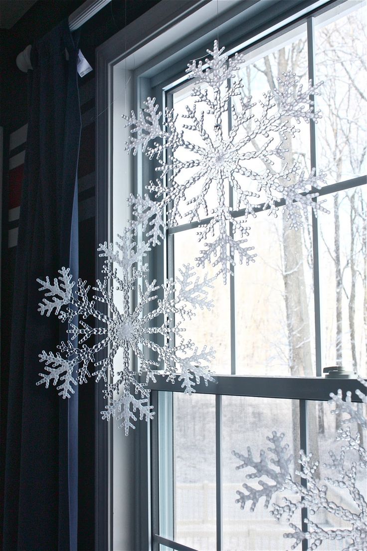 Large snowflakes hung with fishing wire in a window as decorations.