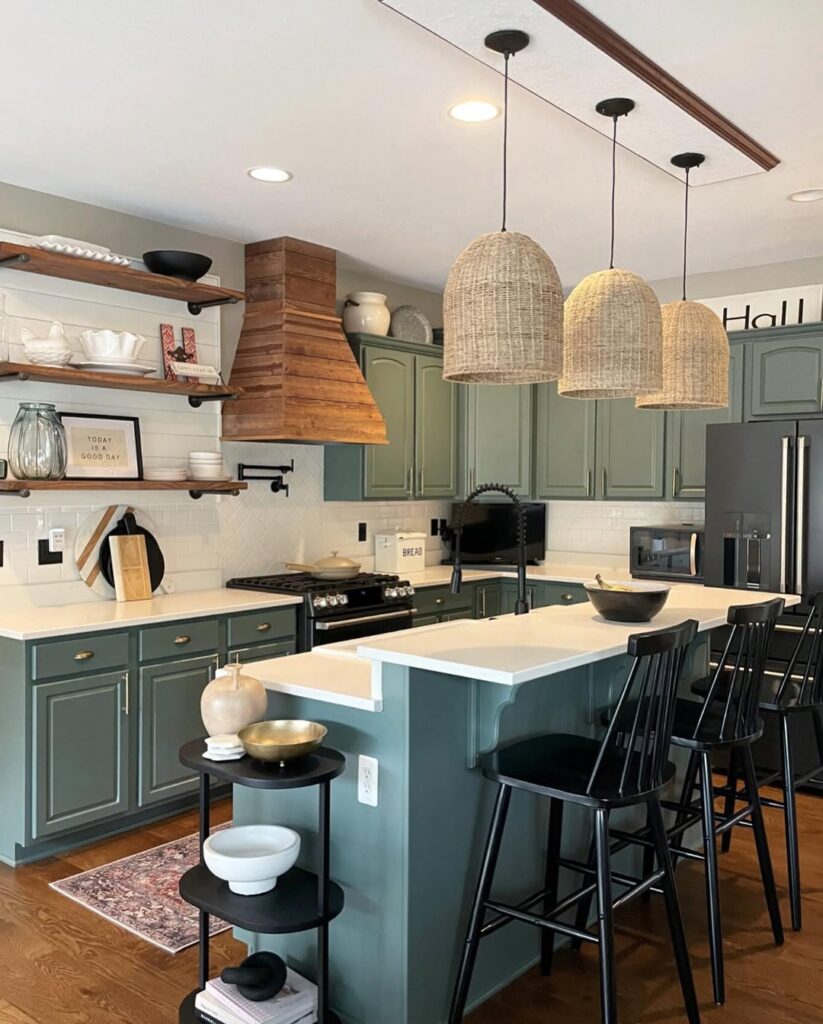 Sage cabinetry and rustic wood details in a warm kitchen