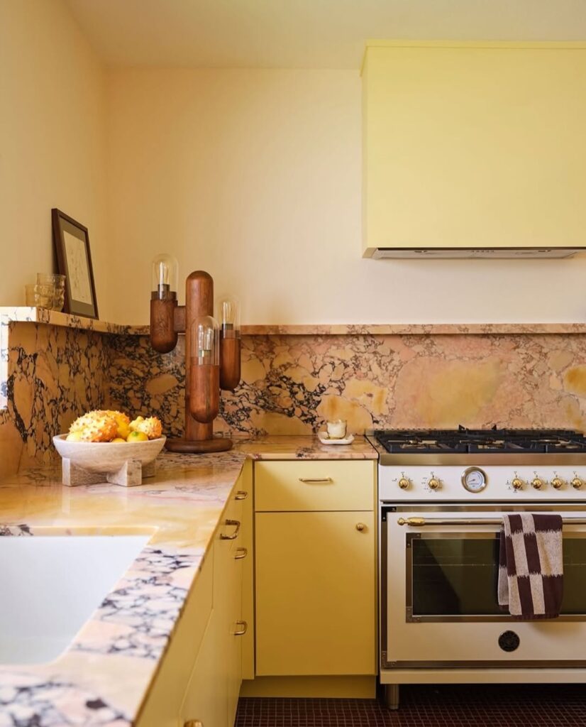 Marble Backsplash With Yellow Cabinetry