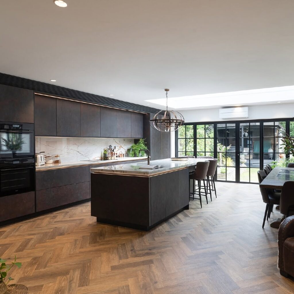 Slate Black Cabinetry with Wraparound Marble and Herringbone Flooring
