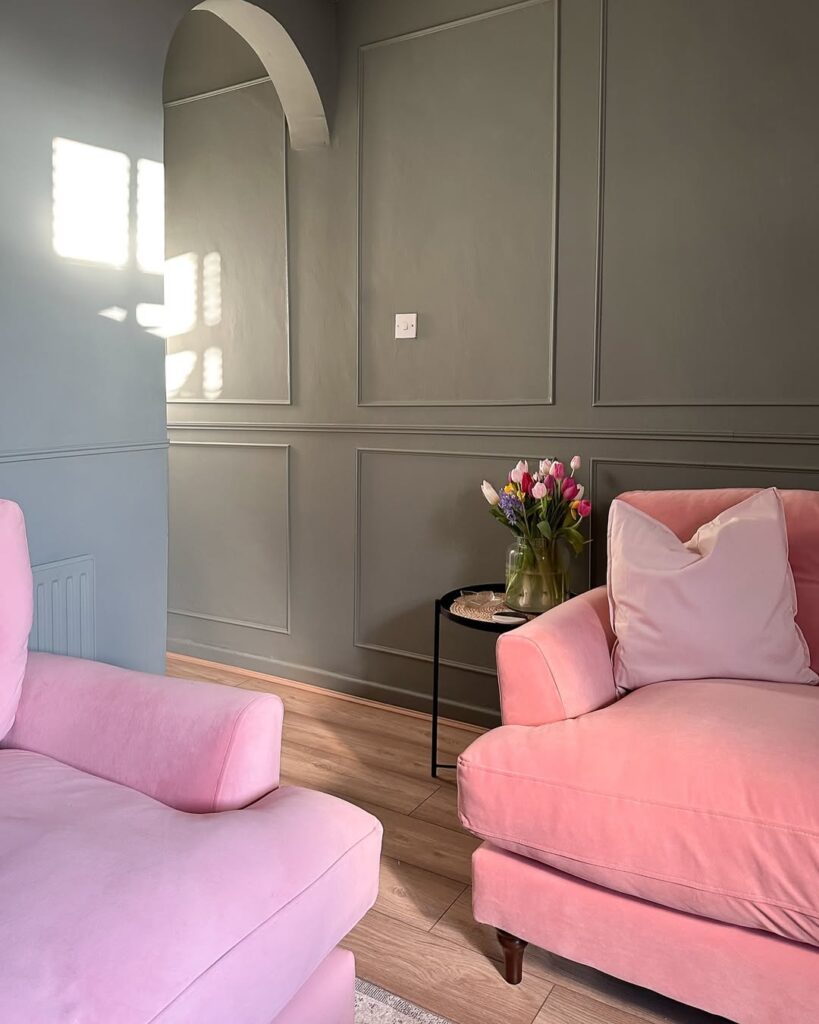 Blush velvet seats beside sage paneled walls