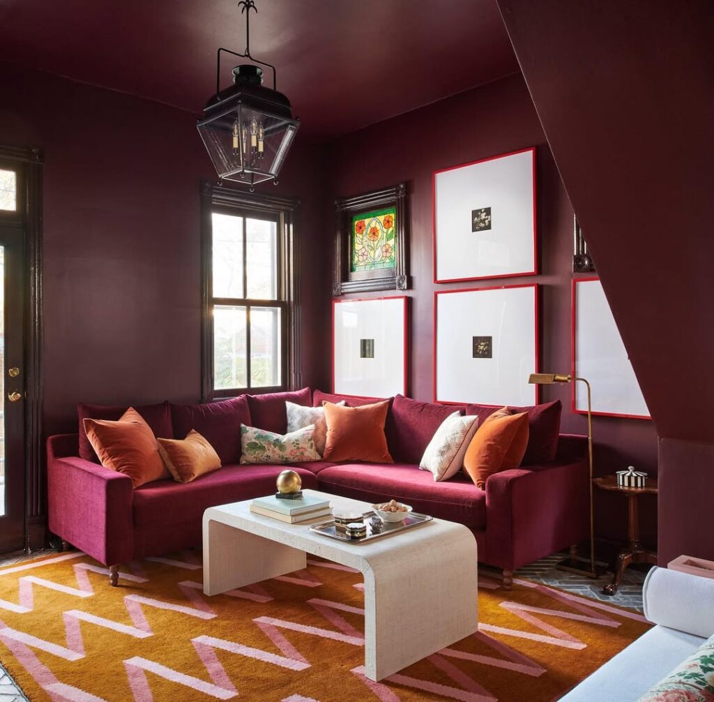 Burgundy lounge featuring a graphic rug in a jewel-toned setting