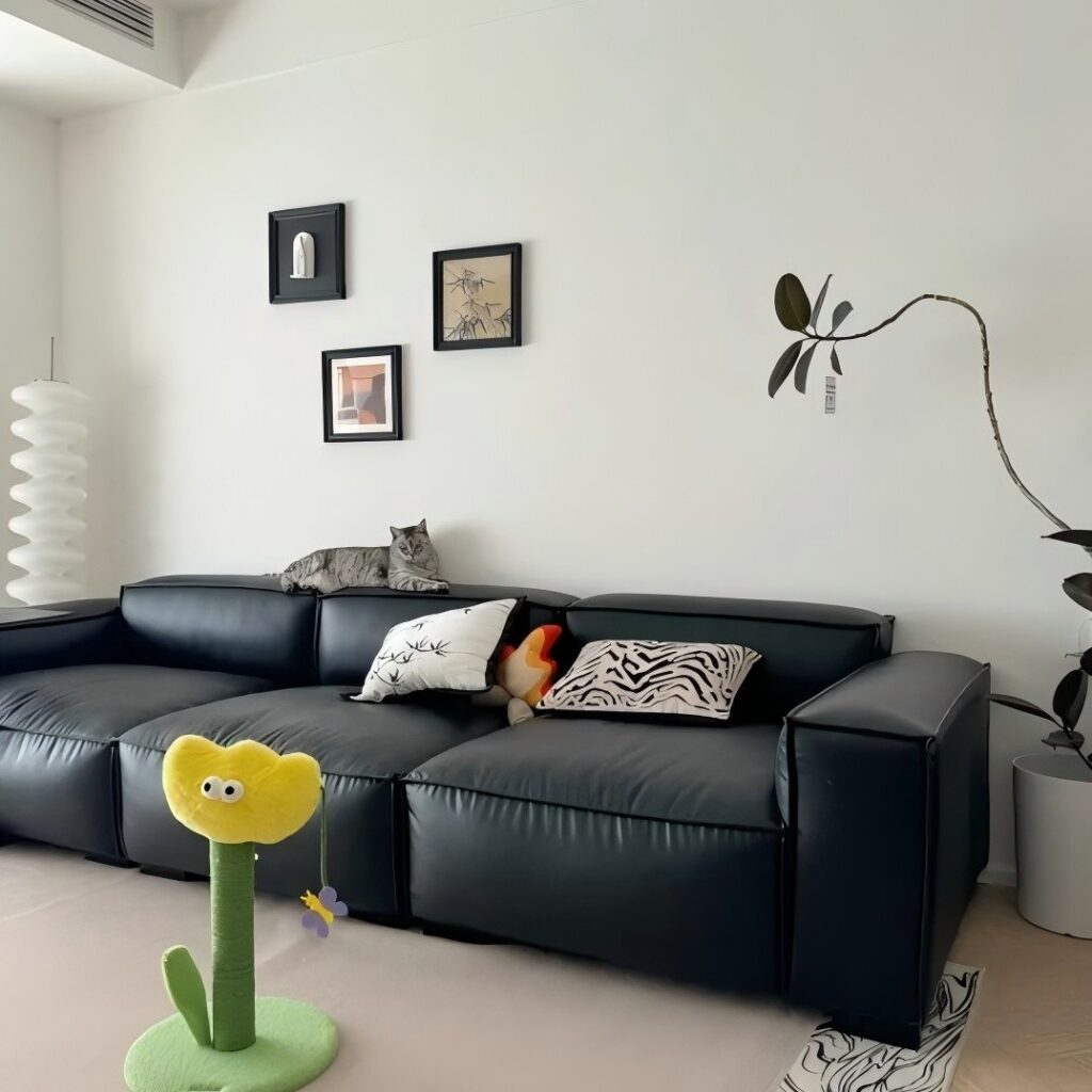 Modern Minimal Space Anchored by Black Sofa and Playful Accent
