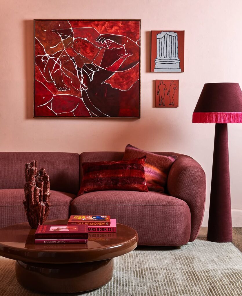 Monochrome sofa set in burgundy beside statement art