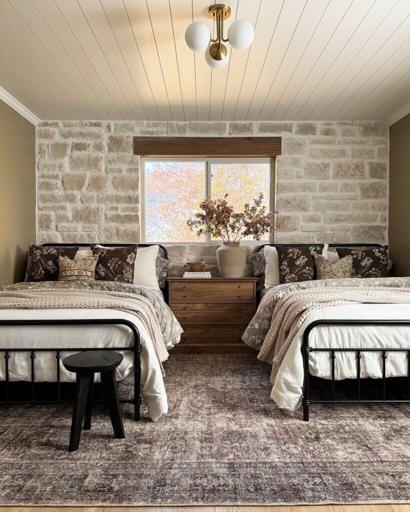 Multiple Metal Frame Beds by a Stone Accent Wall