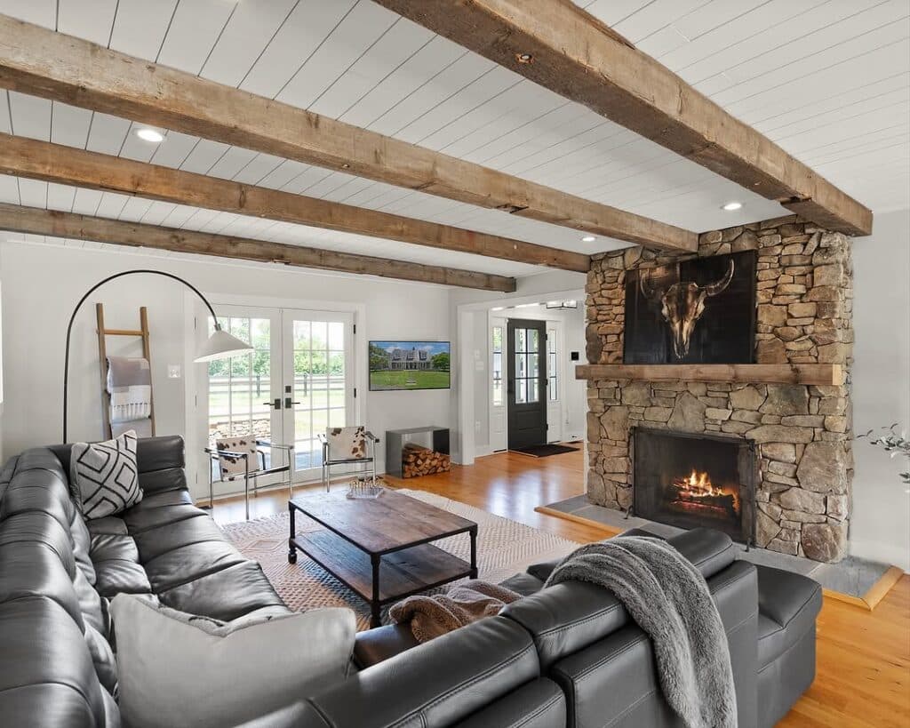 Rustic Farmhouse Living Room with Time-Worn Beam and Stone Hearth
